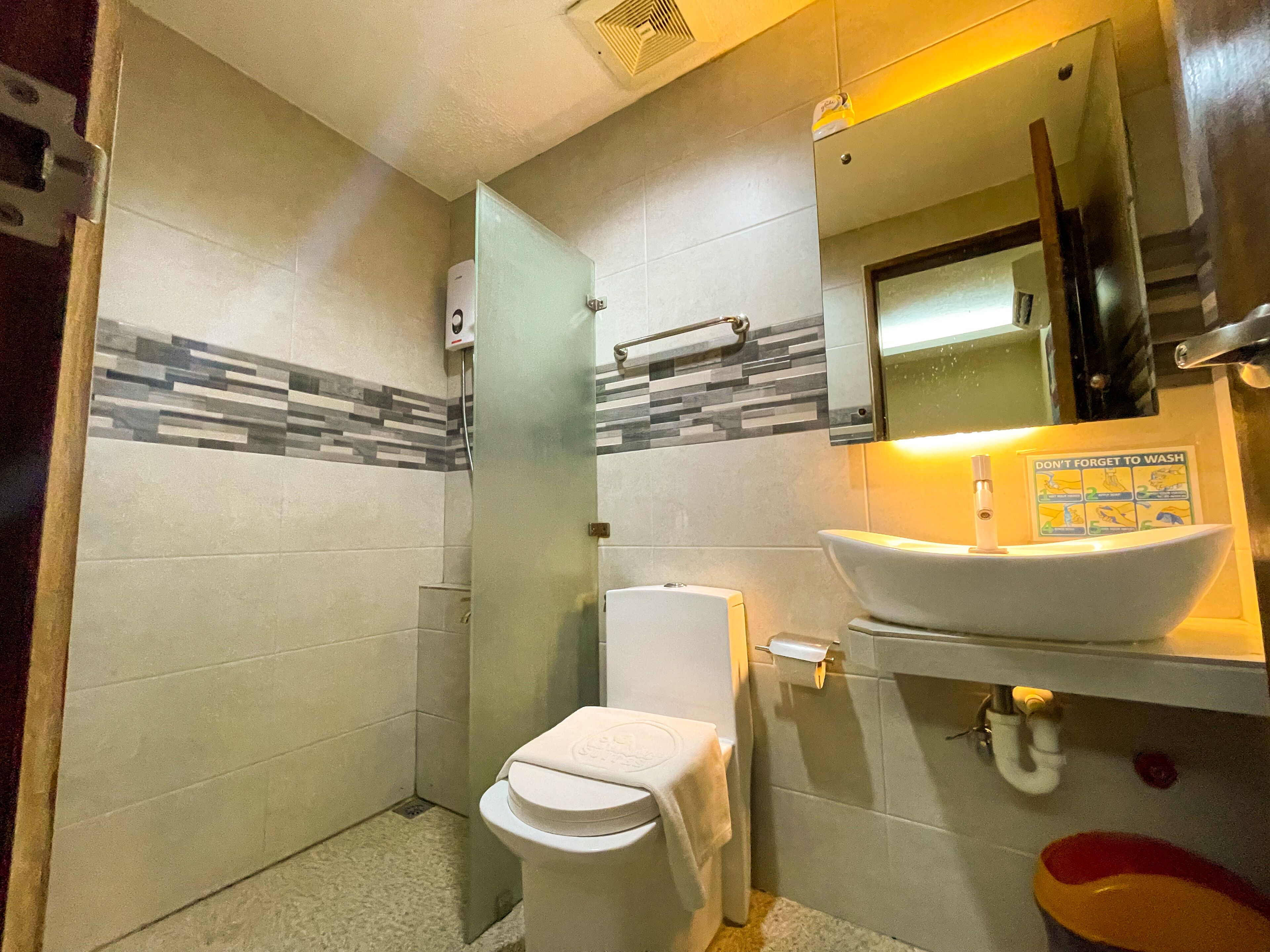 A bathroom with a toilet, a sink, and a shower.