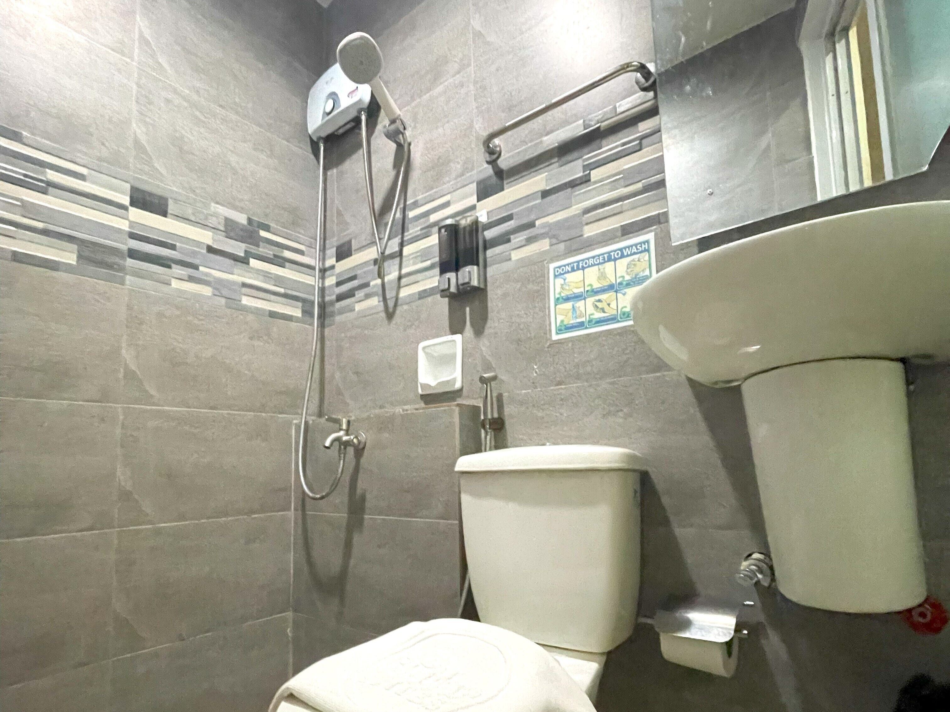A bathroom with a shower, toilet, and sink.