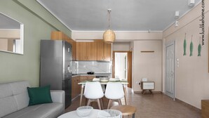 Una cucina moderna con frigorifero, mobili in legno e un'area pranzo con tavolo e sedie.