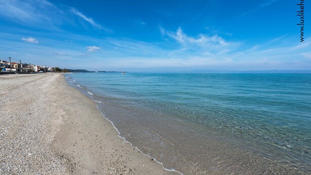 Una spiaggia con acqua cristallina e un litorale ciottoloso.