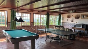 A room with a pool table, a ping pong table, and a billiards table.