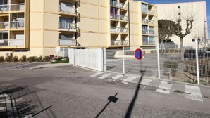 A multi-story yellow building with balconies, a gated entrance, and a no parking sign. - Lovely 1-bedroom apartment with open view, loggia, elevator and wifi in Balaruc-les-Bains (Balaruc-les-Bains)