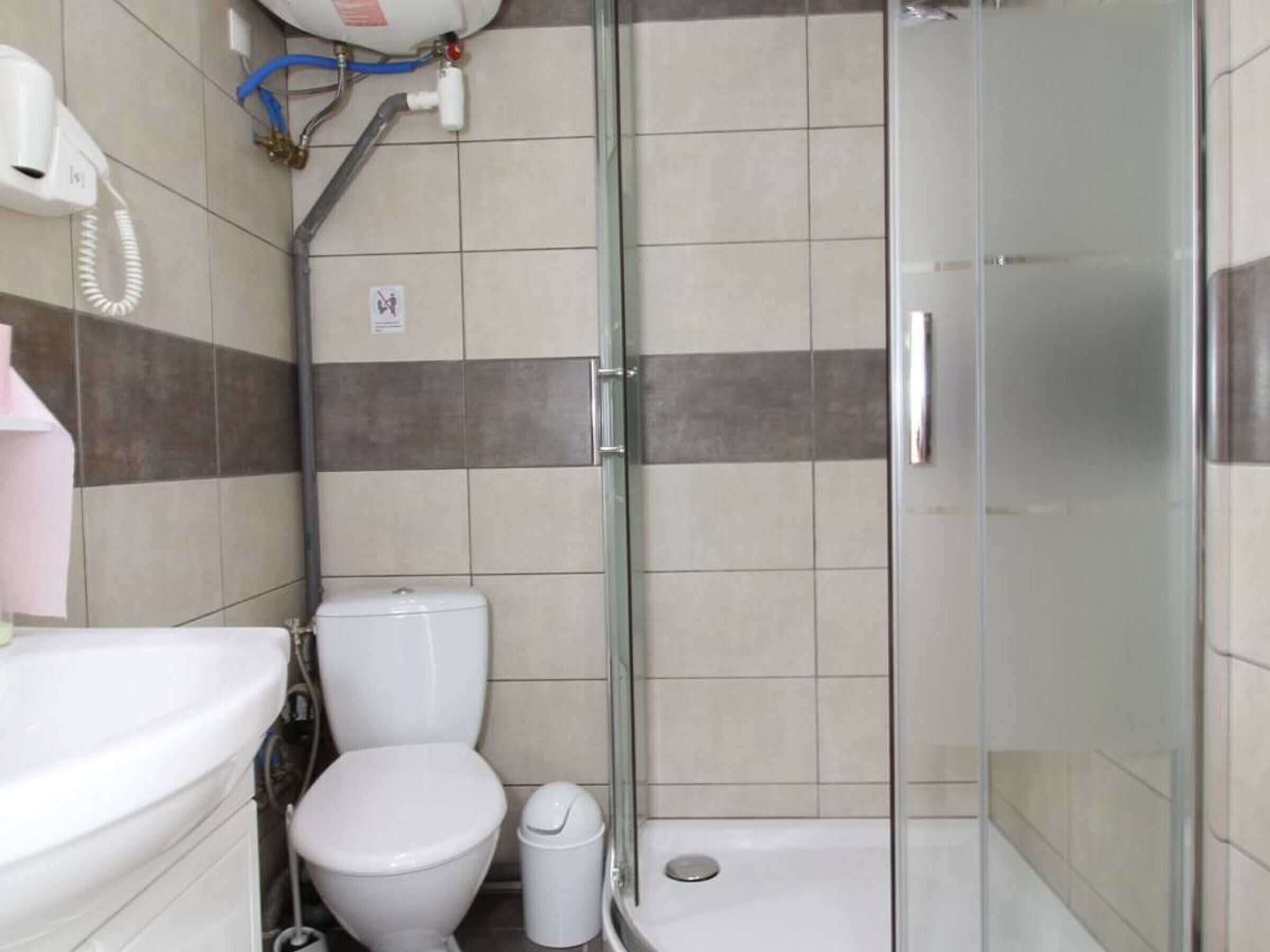 Een badkamer met toilet, wastafel en een douchecabine.