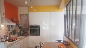 Una cocina compacta con armarios blancos, una mesa de comedor de madera y una ventana con vistas.