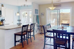 Une cuisine avec un îlot central, des chaises et une table à manger.