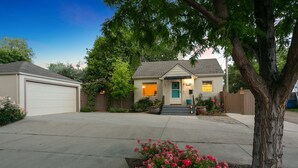A two-story house with a garage, a front porch, and a tree in the driveway. - 1938 Cottage | Newly Remodeled | Coveted North End (Boise)