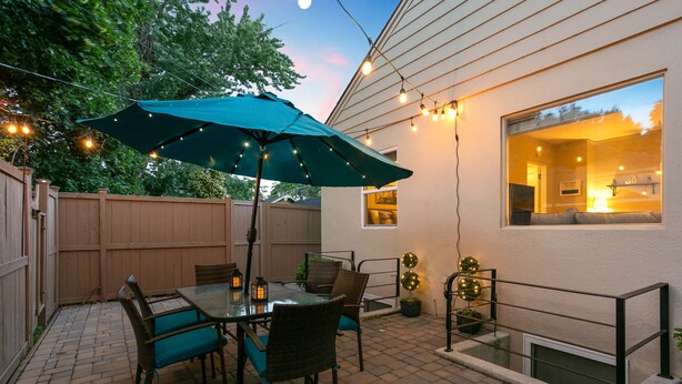 A patio with a table and chairs, an umbrella, string lights, and a view of the house. - 1938 Cottage | Newly Remodeled | Coveted North End (Boise)