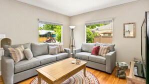 A modern living room with two grey sofas, a wooden coffee table, and a floor lamp. - 1938 Cottage | Newly Remodeled | Coveted North End (Boise)