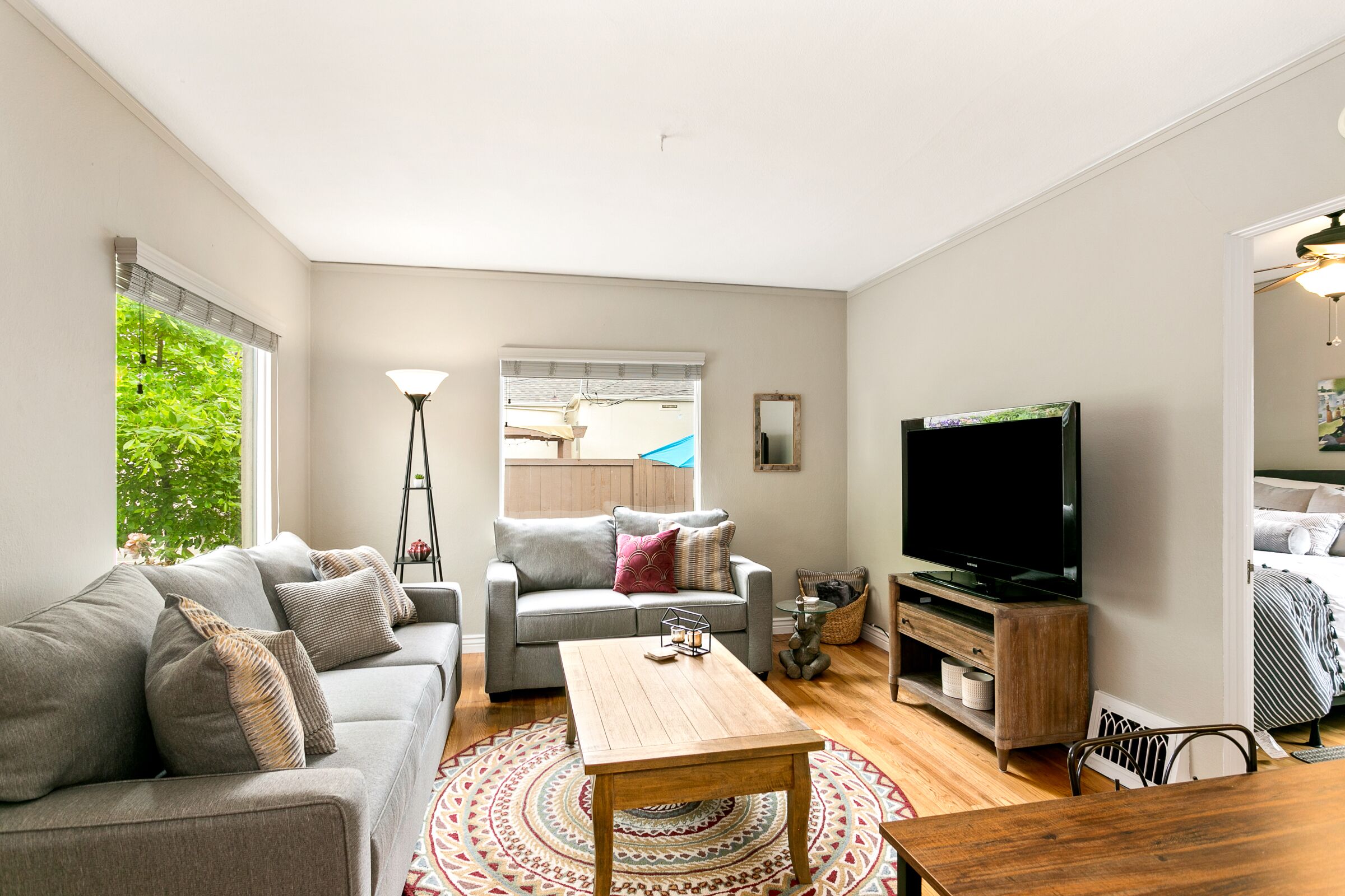 A living room with a sofa, a coffee table, a TV, and a wooden TV stand.