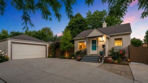 A two-story house with a garage, a front porch, and a well-maintained garden. - CUTE Studio | Newly Remodeled | Blocks To Downtown (Boise)