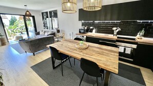 A modern kitchen with a wooden table, black chairs, and a black brick backsplash. - 51 - Apartment in Riviera walking distance to everything (Mijas Costa)
