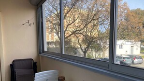 A room with a large window, two chairs, a small table, and a jar on the table. - Cozy Studio with Parking, AC, and WiFi in Balaruc-les-Bains (Balaruc-les-Bains)