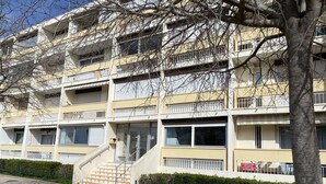 A multi-story residential building with balconies, a staircase leading to the entrance, and a parking sign indicating a 2-hour parking limit. - Cozy Studio with Parking, AC, and WiFi in Balaruc-les-Bains (Balaruc-les-Bains)