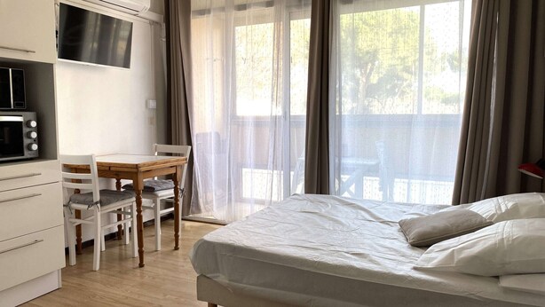 A bedroom with a bed, a desk, and a chair. - Cozy Studio with Parking, AC, and WiFi in Balaruc-les-Bains (Balaruc-les-Bains)