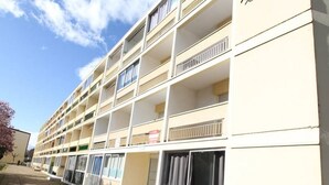 Ein mehrstöckiges Hotel mit Balkonen an jeder Etage, einer schlichten Fassade und blauem Himmel.