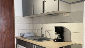 Eine moderne Küche mit Einbauwaschmaschine, Kaffeemaschine und Spüle.