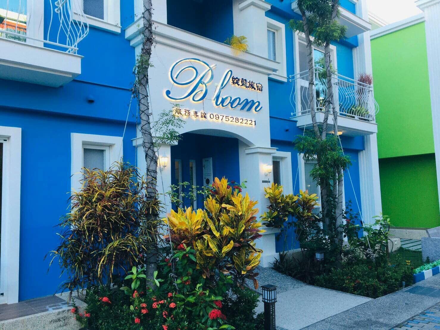 Un hotel con fachada azul y un letrero que dice "Bloom".
