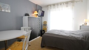 Ein Schlafzimmer mit Bett, Schreibtisch, Stuhl und Kleiderschrank.