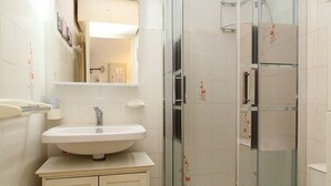 Ein Badezimmer mit Waschbecken, Spiegel und Dusche.