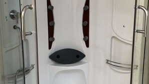Une salle de bain avec une douche, des toilettes et un lavabo.