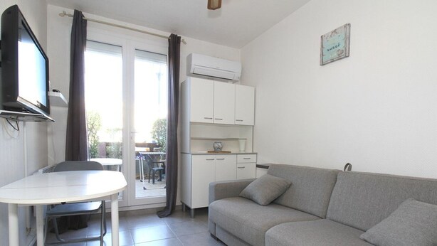 A compact living space with a kitchenette, a dining area, and a sofa. - Cozy Studio with Garden, Near Thermes, WiFi, AC (Balaruc-les-Bains)