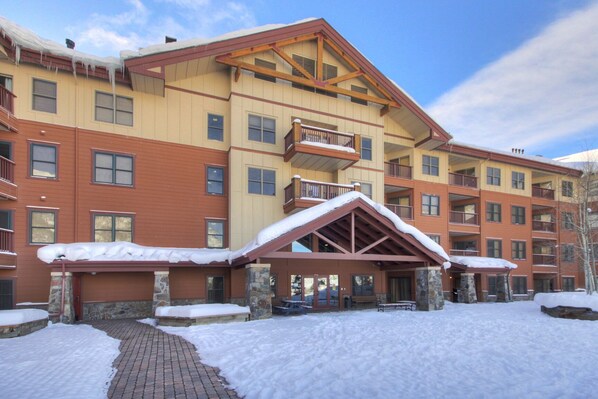 A multi-story hotel with a snow-covered entrance and stone pillars.