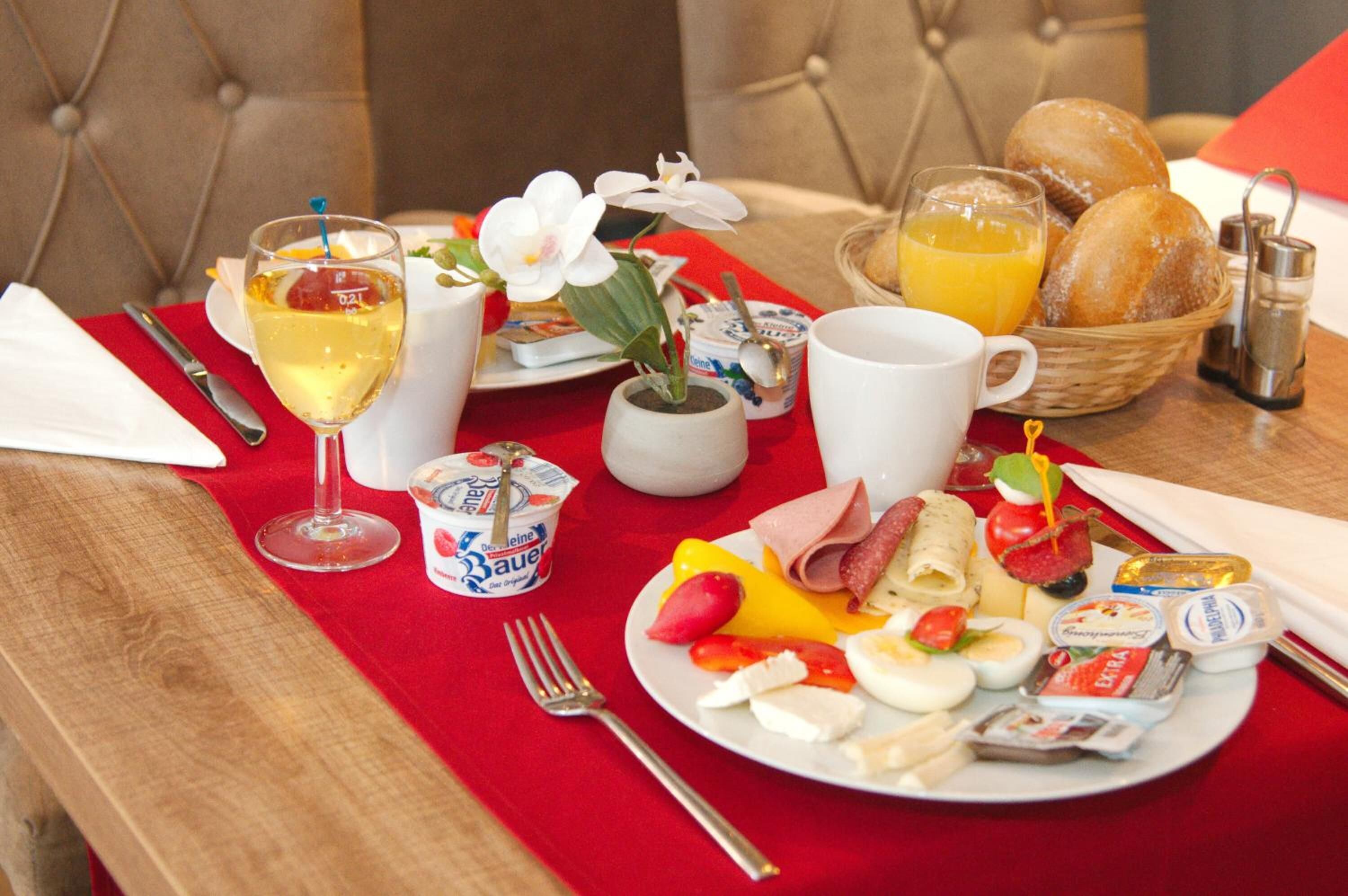 A breakfast setting with a plate of eggs, ham, and cheese, a glass of orange juice, and a cup of coffee.