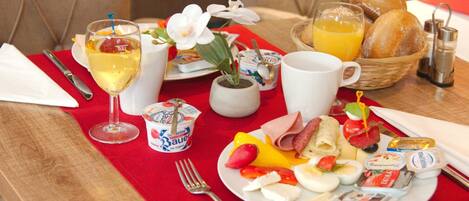 A breakfast setting with a plate of eggs, ham, and cheese, a glass of orange juice, and a cup of coffee.