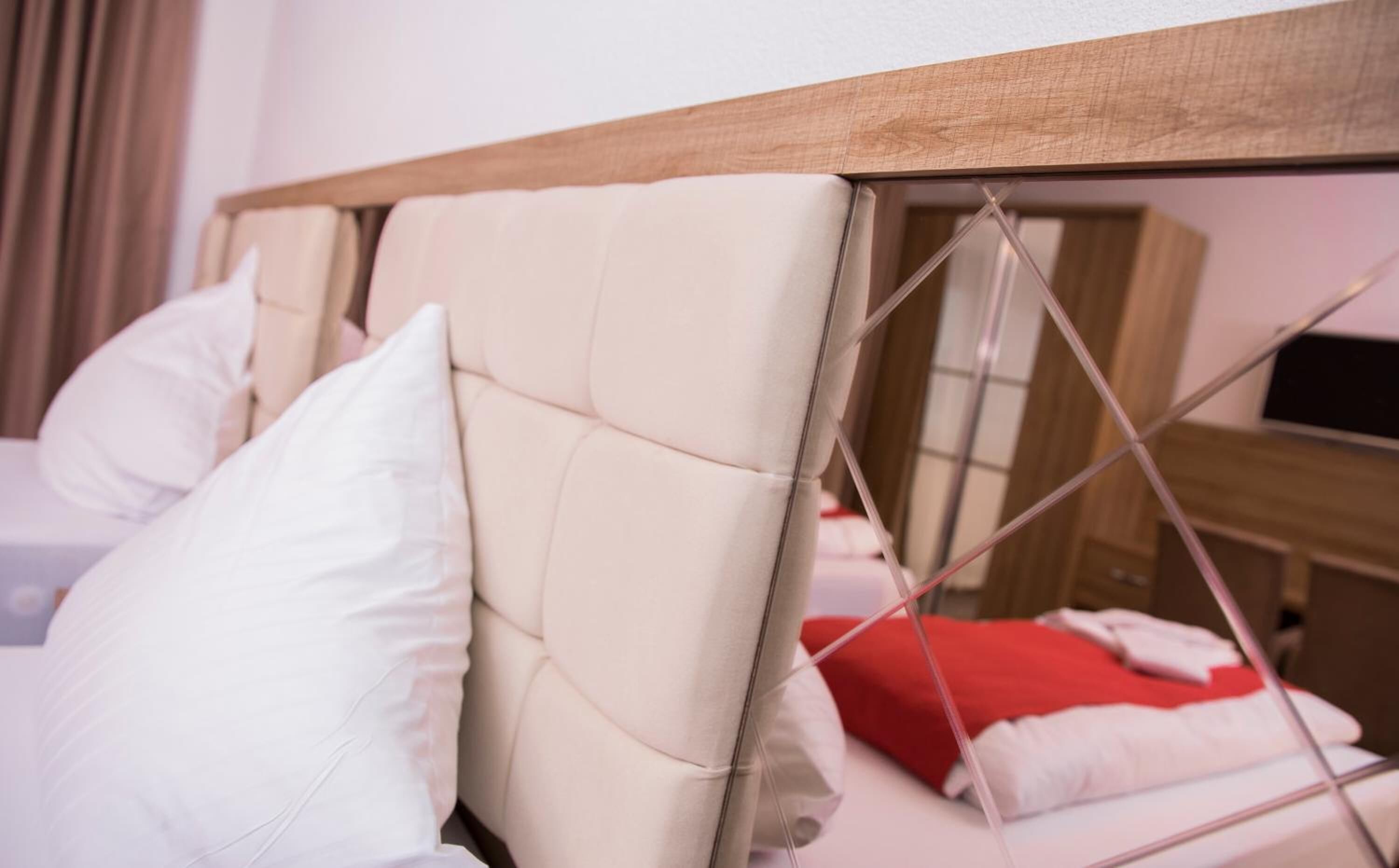 Una cama con cabecera de madera y almohadas blancas.