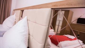 Una cama con cabecera de madera y almohadas blancas.