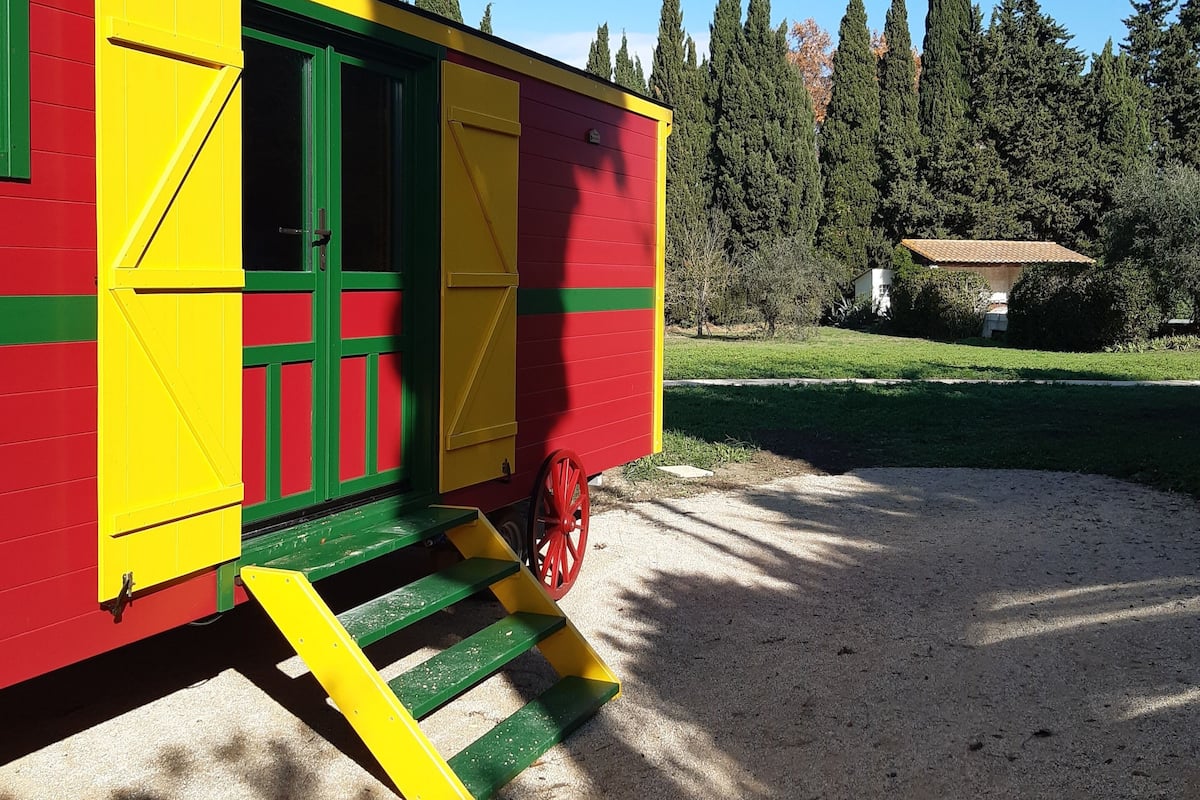 A colorful building with a green door and yellow steps leading up to a red door.