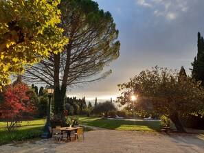 A garden with a table and chairs, a lamp post, and a flag. - Rémy A Dit (St.-Rémy-de-Provence)