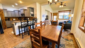 A spacious kitchen with a dining area, wooden chairs, a large rug, and a ceiling fan. - Pet-Friendly Driggs Condo Near Targhee (Driggs)
