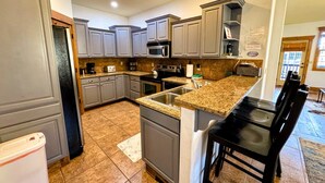 A kitchen with granite countertops, stainless steel appliances, and grey cabinetry. - Pet-Friendly Driggs Condo Near Targhee (Driggs)