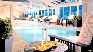 A poolside area with lounge chairs, a table with fruit, and a glass-enclosed ceiling. - Mountain Thunder Townhome • Ski-In • Pools Hot Tubs • Walk to Main St (Breckenridge)