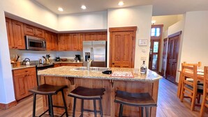 A modern kitchen with wooden cabinets, stainless steel appliances, and a granite countertop. - Mountain Thunder Townhome • Ski-In • Pools Hot Tubs • Walk to Main St (Breckenridge)