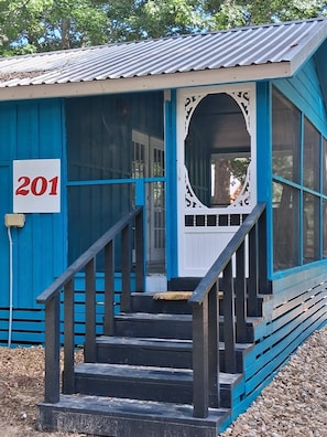 A blue building with a white door and a number '201' sign. - MONTHLY RENTAL, KING BED, HOT TUB, WIFI, KITCHEN, KENNARD TX. 159 HWY 7 #201 (Kennard)