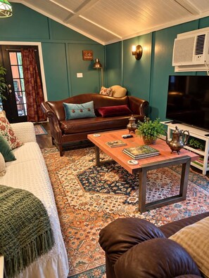 A living room with a brown leather sofa, a wooden coffee table, and a television. - RELAX! UNPLUG, SOAK IN THE HOT TUB, VISIT RATCLIFF LAKE, STAR GAZING (Kennard)