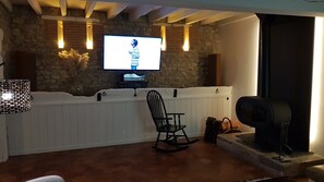 Smart TV, caminetto, libri, impianto stereo