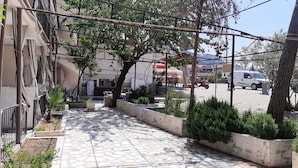 A tiled pathway with planters and a building on one side. - Batu Pansiyon (Denizli)
