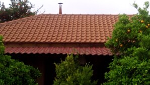 A building with a red-tiled roof and green foliage.