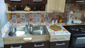 A kitchen with two stainless steel sinks, wooden cabinets, a microwave, and a coffee maker.