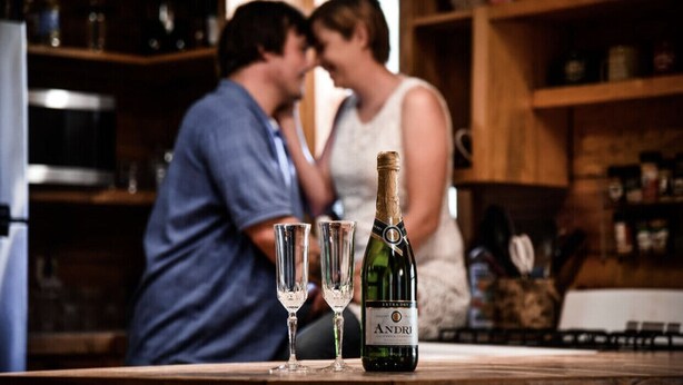 Une bouteille de champagne Andrei et deux verres sur un comptoir.