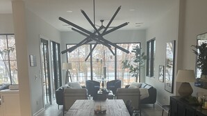 A spacious dining area with a large wooden table, multiple chairs, and a modern chandelier. - Lake Hartwell water front with private dock, sleeps 15 (Hartwell)