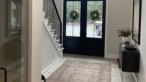 A spacious entrance with a staircase, a black door, and a large window overlooking a garden. - Lake Hartwell water front with private dock, sleeps 15 (Hartwell)