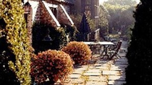 A traditional building with a steeply pitched roof, a stone pathway, and a small table with chairs outside. - Historic Traditional Estate - Heated Pool - Every Amenity (East Hampton)