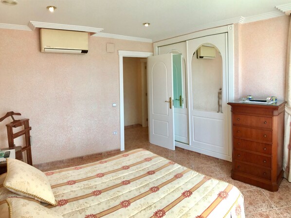 A bedroom with a bed, a dresser, a wardrobe, and an air conditioning unit. - EUROPA APARTMENT R068 (Benidorm)