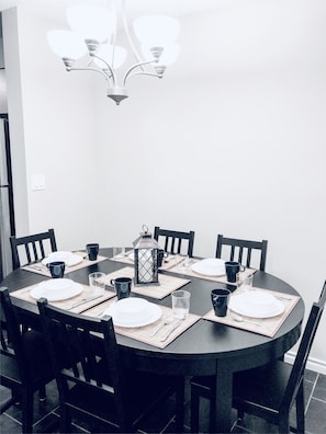 Enjoy meals in style with a round table set for four, surrounded by comfortable chairs and elegant decor.