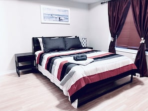 Cozy retreat with a neatly made bed, nightstand, and framed picture.