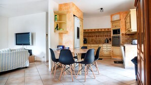 Una cocina moderna con comedor, que incluye un televisor, un sofá y un mueble para TV.